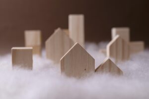 close-up-human-hand-holding-mini-house-model-white-backdrop